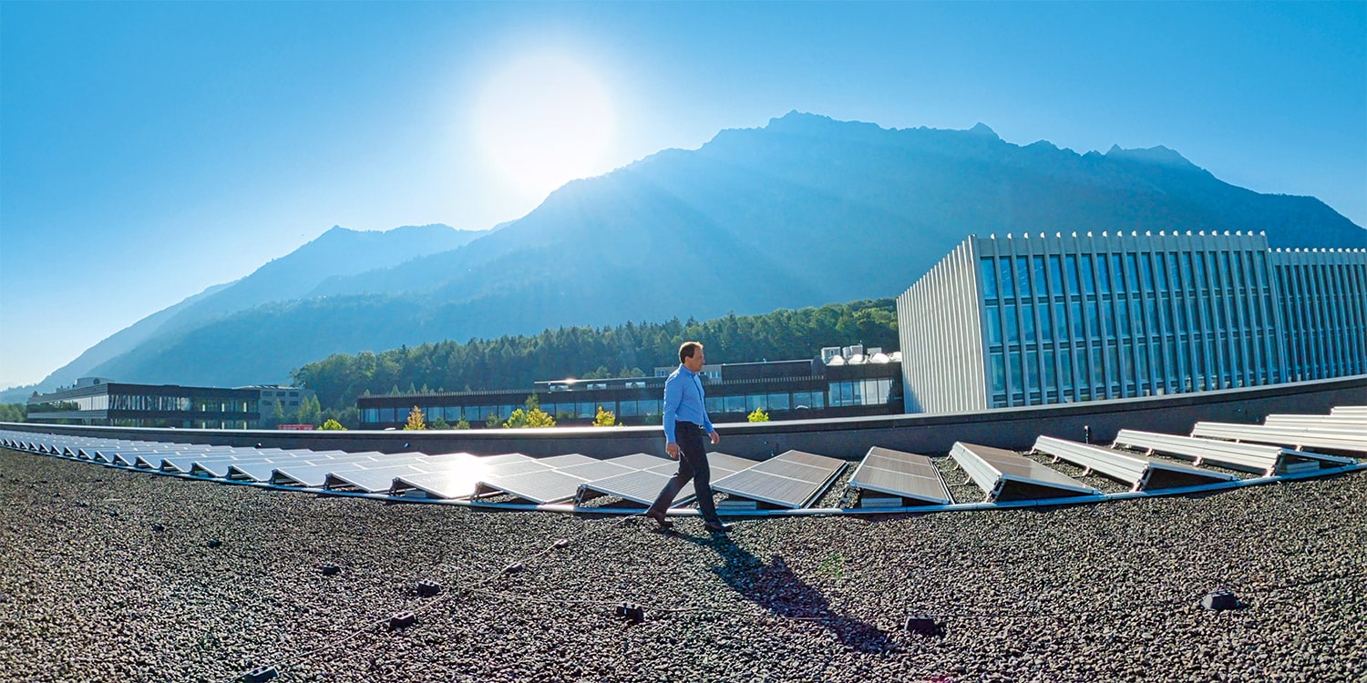 Un collaborateur Hilti marche sur un toit équipé de panneaux solaires 