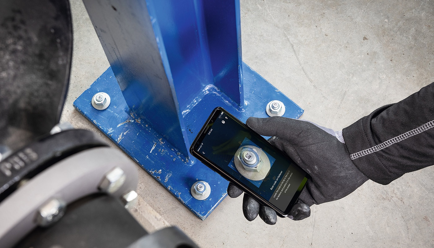 Un ouvrier scanne la cheville Hilti avec son smartphone