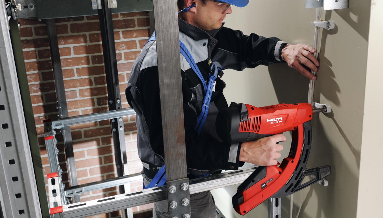 Un technicien en pleine fixation des équipements d'ascenseurs