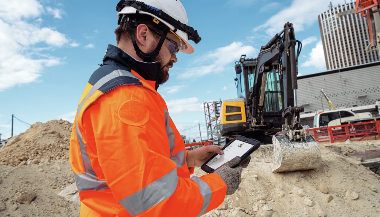 Un ouvrier sur un chantier en train de consulter sa tablette