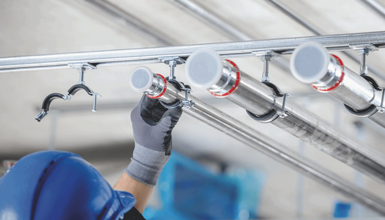 Fixation de colliers Hilti sur des tuyaux au plafond