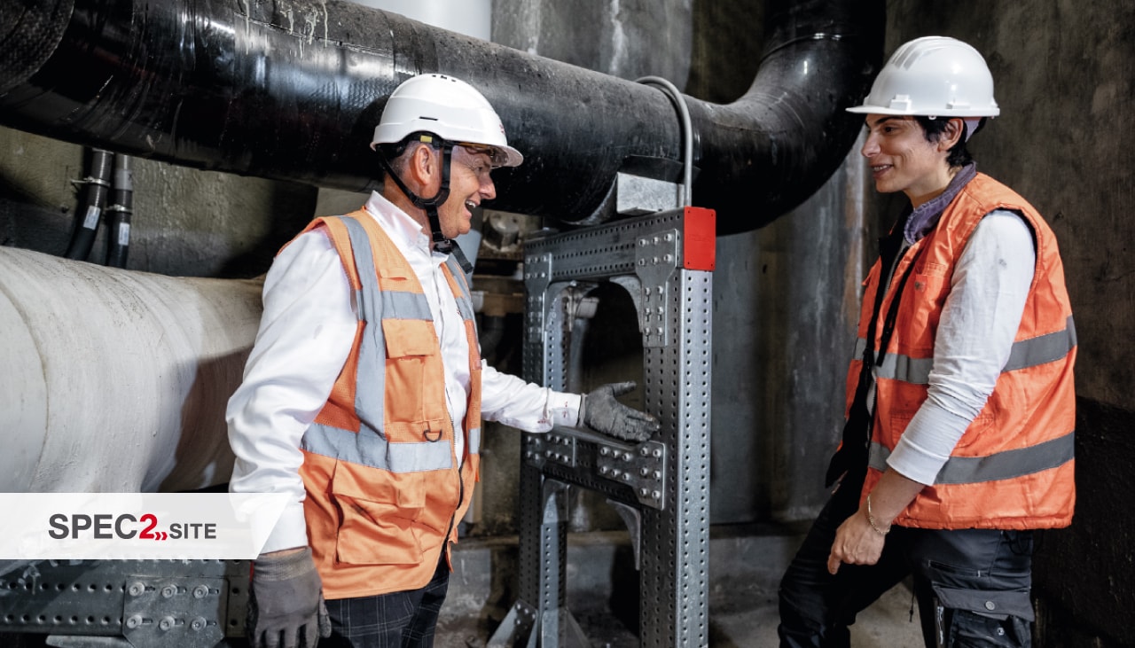 Un ingénieur Hilti et un client inspectent un système de support modulaire pour la tuyauterie.