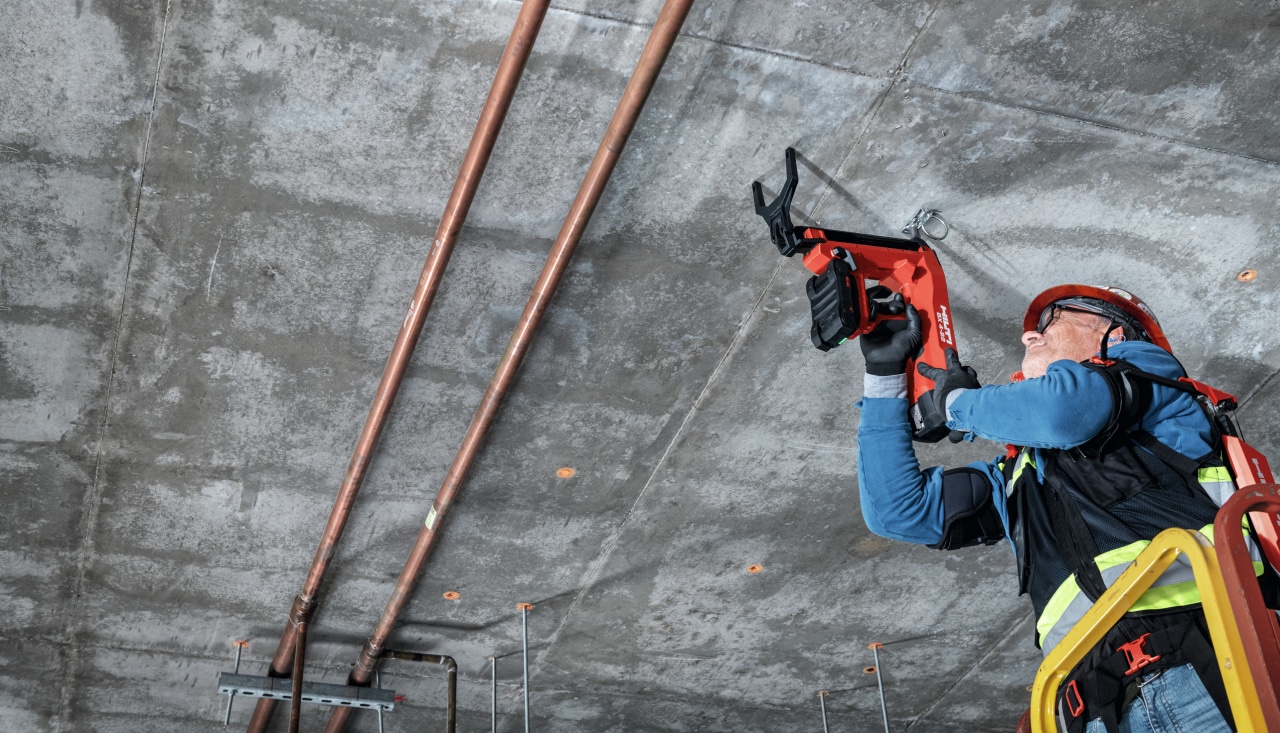 Un ouvrier porte un exo-s pour une tache au dessus des épaules sur un chantier