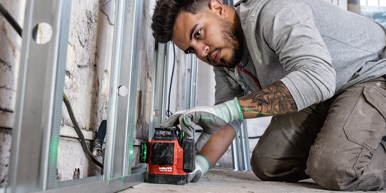Un homme utilise le laser multidirectionnel Hilti PM 30-MG sur un chantier