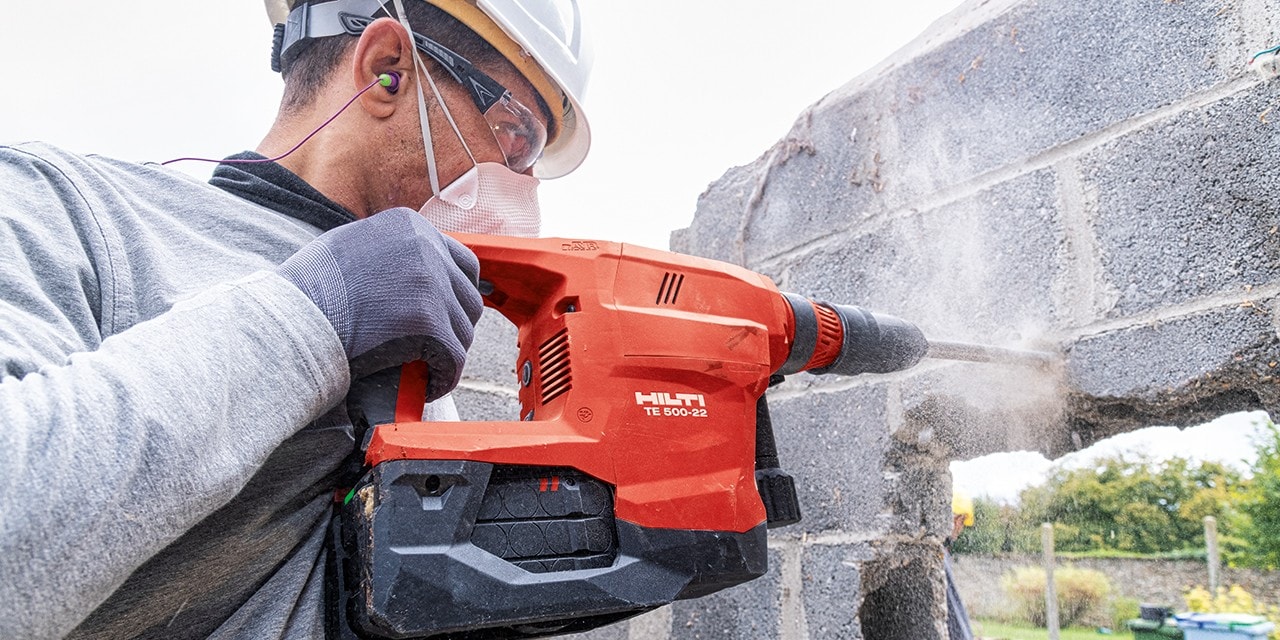Un ouvrier utilise le marteau piqueur sans fil TE 500-22 SDS pour démolir un mur