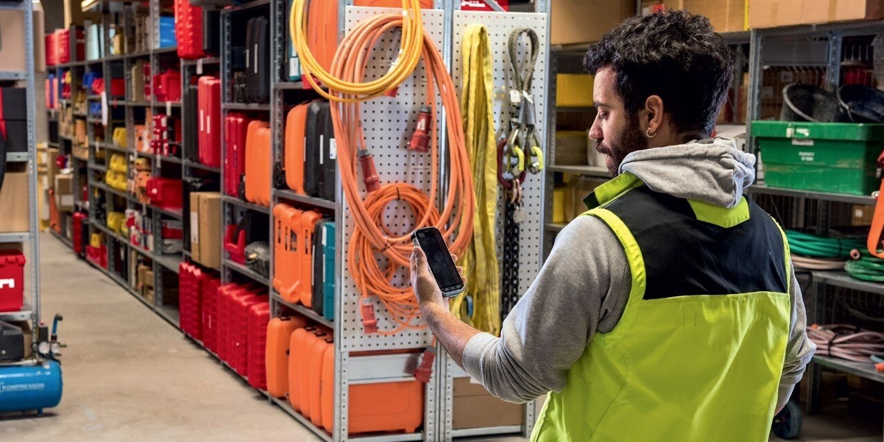 Un magasinier utilise l'application ON!Track Hilti sur son smartphone